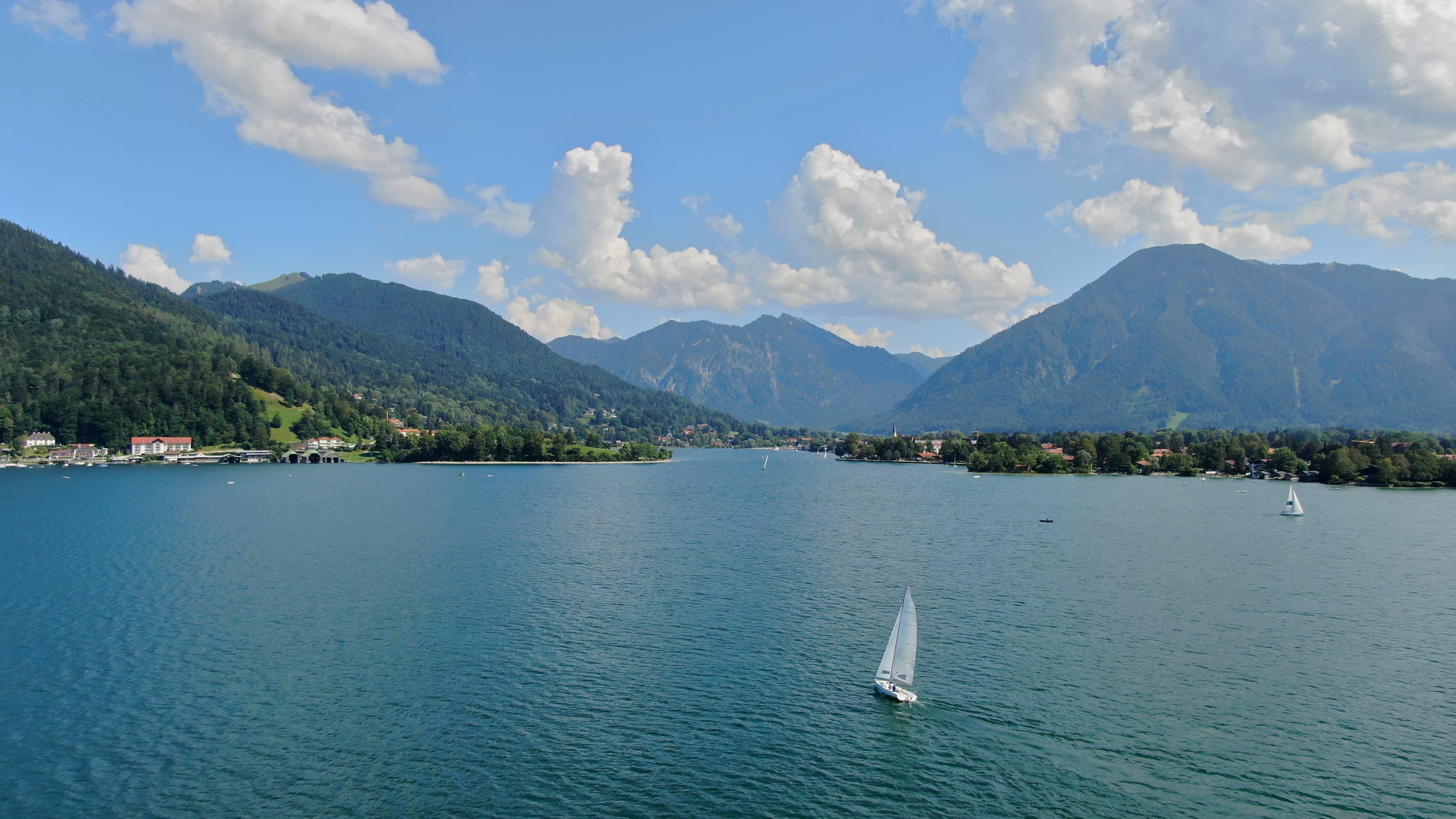 Tegernsee mit Segelboot und Bergkulisse